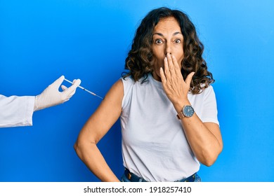 Middle Age Hispanic Woman Getting Vaccine Covering Mouth With Hand, Shocked And Afraid For Mistake. Surprised Expression 