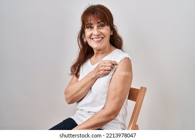 Middle Age Hispanic Woman Getting Vaccine Showing Arm With Band Aid With A Happy And Cool Smile On Face. Lucky Person. 