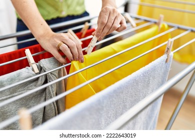 Middle Age Hispanic Woman Hanging Clotnes At Laundry Room