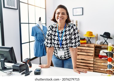 Middle Age Hispanic Woman Shopkeeper Working At Clothing Store