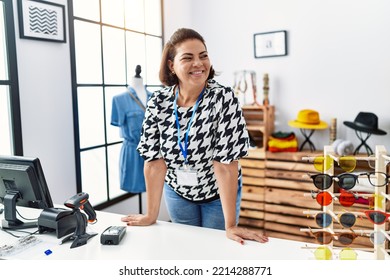 Middle Age Hispanic Woman Shopkeeper Working At Clothing Store