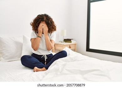 Middle Age Hispanic Woman Sitting On The Bed At Home With Sad Expression Covering Face With Hands While Crying. Depression Concept. 