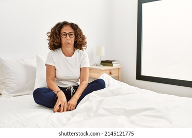 Middle Age Hispanic Woman Sitting On The Bed At Home Depressed And Worry For Distress, Crying Angry And Afraid. Sad Expression. 