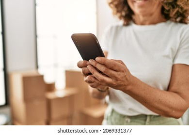 Middle Age Hispanic Woman Smiling Confident Using Smartphone At New Home