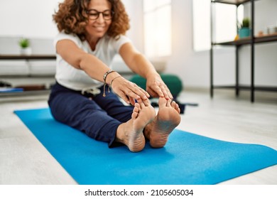 Middle Age Hispanic Woman Smiling Confident Stretching At Home