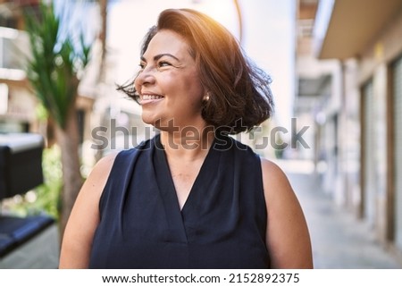 Middle age hispanic woman smiling happy and confident outdoors on a sunny day