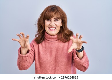 Middle Age Hispanic Woman Standing Over Isolated Background Smiling Funny Doing Claw Gesture As Cat, Aggressive And Sexy Expression 