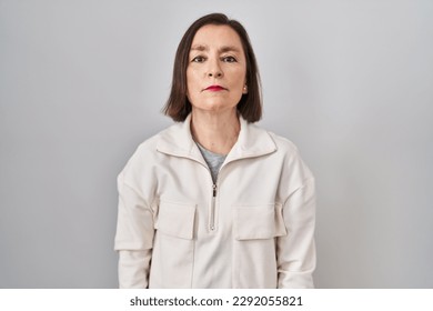 Middle age hispanic woman standing over isolated background relaxed with serious expression on face. simple and natural looking at the camera.  - Shutterstock ID 2292055821