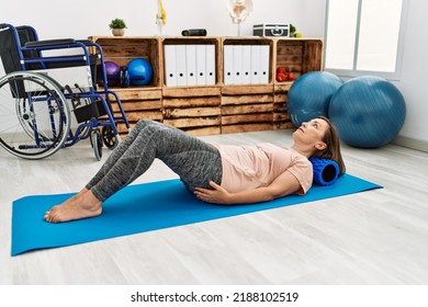 Middle Age Hispanic Woman Training Abdominal Muscles At Physiotherapy Clinic