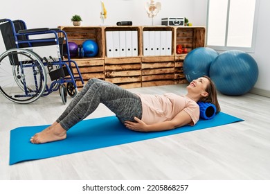 Middle Age Hispanic Woman Training Abdominal Muscles At Physiotherapy Clinic