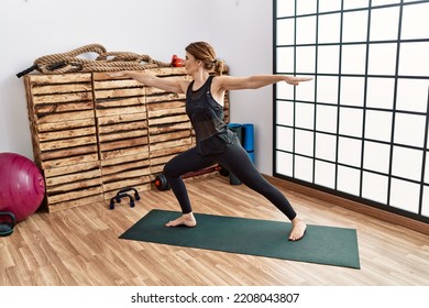 Middle Age Hispanic Woman Training Yoga At Sport Center