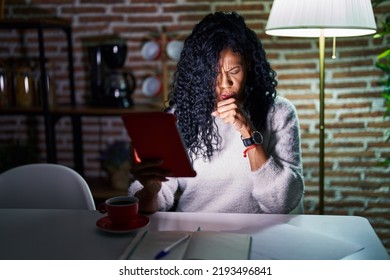 Middle Age Hispanic Woman Using Touchpad Sitting On The Table At Night Feeling Unwell And Coughing As Symptom For Cold Or Bronchitis. Health Care Concept. 