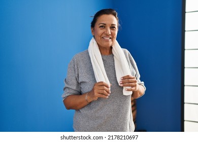 Middle Age Hispanic Woman Wearing Sportswear Standing At Laundry Room