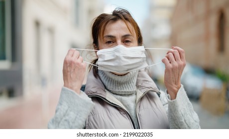 Middle Age Hispanic Woman Wearing Medical Mask At Street