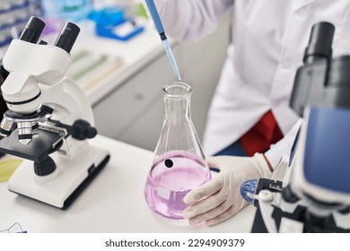 Middle age hispanic woman wearing scientist uniform using pipette at laboratory - Powered by Shutterstock