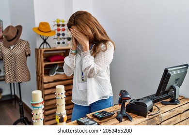 Middle Age Hispanic Woman Working As Manager At Retail Boutique With Sad Expression Covering Face With Hands While Crying. Depression Concept. 