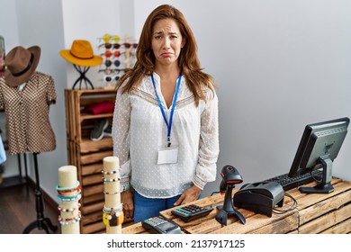 Middle age hispanic woman working as manager at retail boutique depressed and worry for distress, crying angry and afraid. sad expression. 