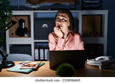 Middle Age Hispanic Woman Working Using Computer Laptop Late At Night Looking Stressed And Nervous With Hands On Mouth Biting Nails. Anxiety Problem. 