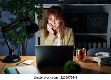 Middle Age Hispanic Woman Working Using Computer Laptop At Night Looking Stressed And Nervous With Hands On Mouth Biting Nails. Anxiety Problem. 