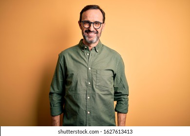 Middle Age Hoary Man Wearing Casual Green Shirt And Glasses Over Isolated Yellow Background With A Happy And Cool Smile On Face. Lucky Person.