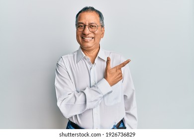 Middle Age Indian Man Wearing Casual Clothes And Glasses Cheerful With A Smile Of Face Pointing With Hand And Finger Up To The Side With Happy And Natural Expression On Face 