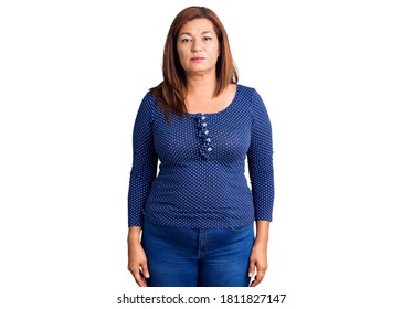 Middle age latin woman wearing casual clothes with serious expression on face. simple and natural looking at the camera. 