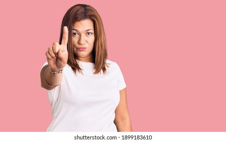 Middle Age Latin Woman Wearing Casual White Tshirt Pointing With Finger Up And Angry Expression, Showing No Gesture 