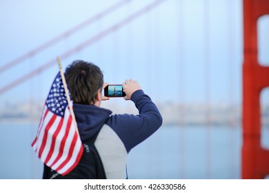 Middle age man with american flag in backpack making mobile photo on famous Golden Gate bridge in San Francisco, California, USA
 - Powered by Shutterstock