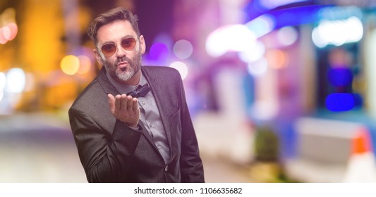 Middle Age Man, With Beard And Bow Tie Expressing Love, Blows Kiss At Camera, Flirting At Night Club