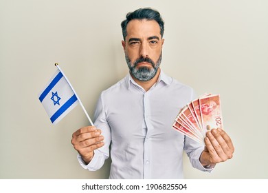 Middle Age Man With Beard And Grey Hair Holding Israel Flag And Shekels Banknotes Depressed And Worry For Distress, Crying Angry And Afraid. Sad Expression. 