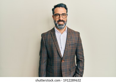 Middle age man with beard and grey hair wearing business jacket and glasses with a happy and cool smile on face. lucky person. 