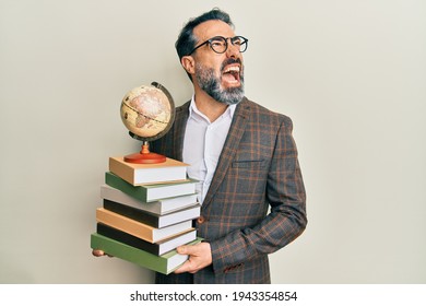 Middle Age Man With Beard And Grey Hair Teacher Holding Vintage World Ball Angry And Mad Screaming Frustrated And Furious, Shouting With Anger Looking Up. 