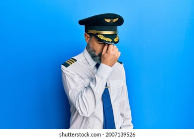 Middle Age Man With Beard And Grey Hair Wearing Airplane Pilot Uniform Tired Rubbing Nose And Eyes Feeling Fatigue And Headache. Stress And Frustration Concept. 