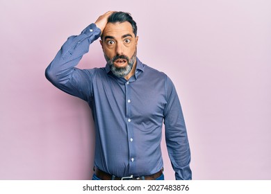 Middle Age Man With Beard And Grey Hair Wearing Business Clothes Surprised With Hand On Head For Mistake, Remember Error. Forgot, Bad Memory Concept. 