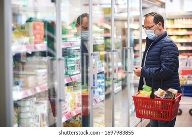 Homem de meia idade comprando comida na mercearia, usando máscara médica