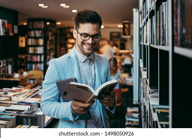 Middle age man choosing and reading books in modern bookstore.