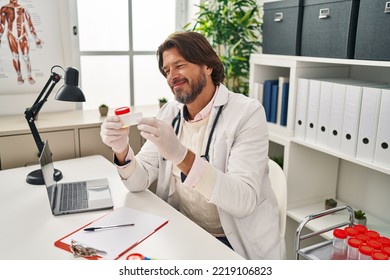 Middle Age Man Doctor Putting Sticker On Urine Test Tube At Clinic