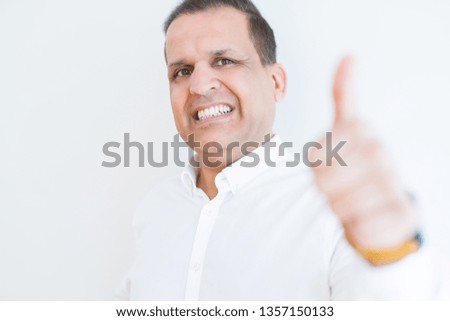 Middle age man doing postive gesture with thumbs up smiling to the camera