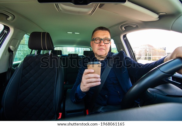 Middle age man drink coffee\
in car