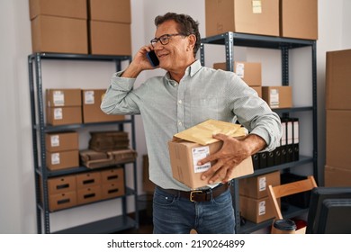 Middle Age Man Ecommerce Business Worker Talking On The Smartphone And Holding Package At Office