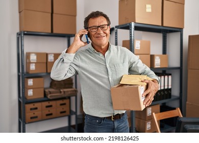 Middle Age Man Ecommerce Business Worker Talking On The Smartphone And Holding Package At Office