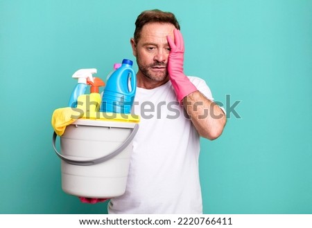 middle age man feeling bored, frustrated and sleepy after a tiresome. housekeeper with clean products
