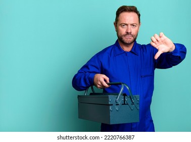 Middle Age Man Feeling Cross,showing Thumbs Down. Plumber With A Toolbox Concept