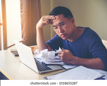 Middle age man feeling sick and tired. Frustrated mature man looking exhausted while sitting at his working place and carrying a paper tissue in hand.  Man sneeze having snot and feeling headache. - Powered by Shutterstock