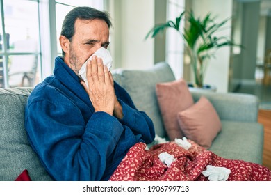 Middle Age Man Feeling Sick With Cold And Fever At Home, Ill With Flu Disease Sitting On The Sofa