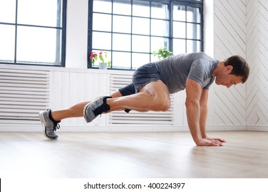 Middle Age Man In A Grey T Shirt Doing Abs Workouts On The Floor.