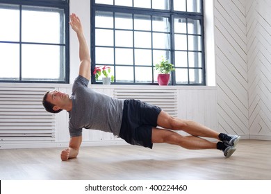 Middle Age Man In A Grey T Shirt Doing Abs Workouts On The Floor.