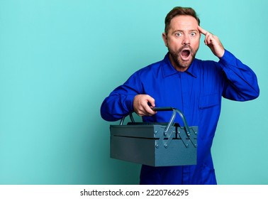 Middle Age Man Looking Surprised, Realizing A New Thought, Idea Or Concept. Plumber With A Toolbox Concept