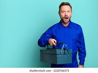 Middle Age Man Looking Very Shocked Or Surprised. Plumber With A Toolbox Concept