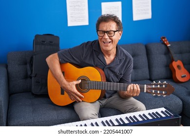 Middle Age Man Musician Singing Song Playing Classical Guitar At Music Studio